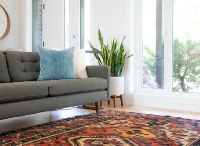 teal 2-seat couch and red area rug