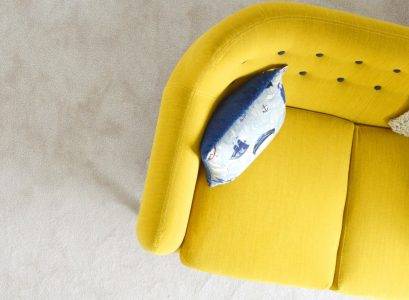 yellow fabric sofa with throw pillow